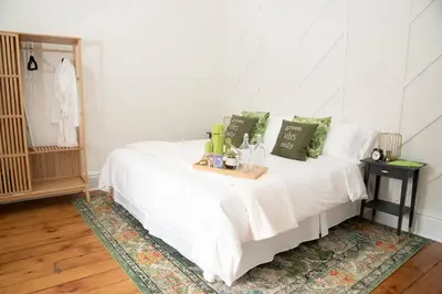 a bedroom with a white bed with a tray on it at The Juniper Inn in St. Catharines
