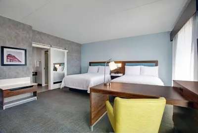 a hotel room with two beds and a desk and a desk at Hampton Inn & Suites By Hilton Waterloo St. Jacobs in Waterloo