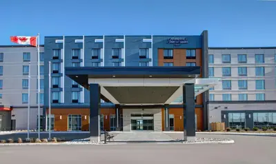 a hotel building with a blue canopy in front of it at Hampton Inn & Suites By Hilton Waterloo St. Jacobs in Waterloo