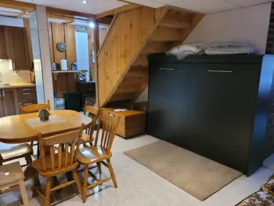 a kitchen and dining room with a table and a staircase at Whispering Pines Suite at The Bowering Lodge in Blue Mountains