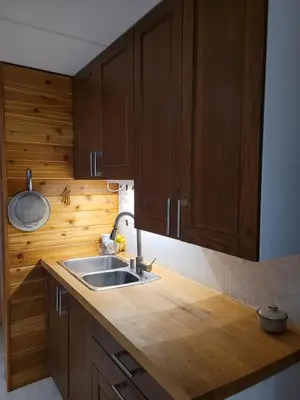 a kitchen with wooden cabinets and a sink at Whispering Pines Suite at The Bowering Lodge in Blue Mountains
