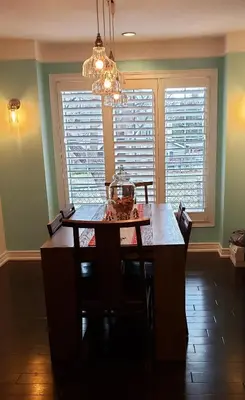 a dining room with a table and a chandelier at La Maison de Sophie in Niagara on the Lake