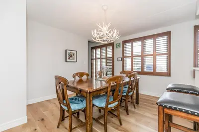 a dining room with a wooden table and chairs at Stunning Townhouse - 3 BDRM Blue Mountain Village Sauna! in Blue Mountains