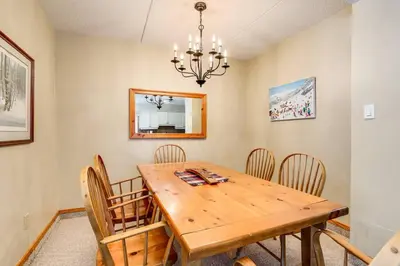 a dining room with a wooden table and chairs at Ski In Out Mountainside Chalet 83001 in Blue Mountains