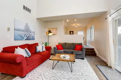 a living room with a red couch and a table at Wintergreen Retreat with Private Sauna & Patio 82291 in Blue Mountains