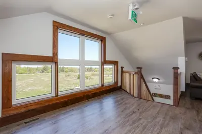 an empty living room with large windows and a staircase at Luxury Mountain Retreat with private hot tub 82958 in Blue Mountains