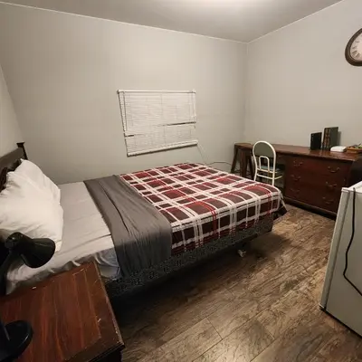 a bedroom with a bed and a desk and a window at Earthquest Lodge in Port Burwell