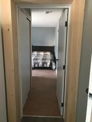 a hallway leading into a bedroom with a bed at Earthquest Lodge in Port Burwell