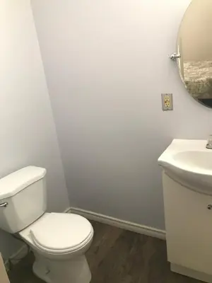 a white bathroom with a toilet and a sink at Earthquest Lodge in Port Burwell