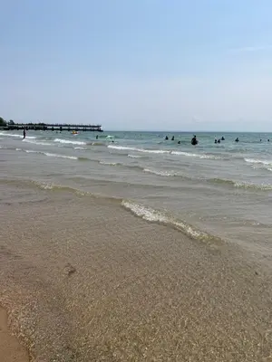 a beach with a group of people in the ocean at THE YORK HOUSE BOUTIQUE Stay in Fort Erie