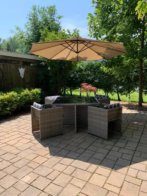 a patio with an umbrella and two chairs under it at THE YORK HOUSE BOUTIQUE Stay in Fort Erie