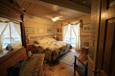 a bedroom with a bed and two windows at Stouffermill Bed & Breakfast in Algonquin Highlands