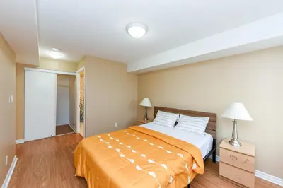 a bedroom with a bed with an orange blanket at PlanURstay - Amazing 2BR & 2BTH - Near Square One Mall in Mississauga
