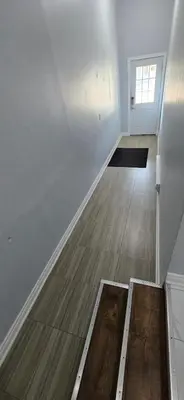 an empty room with a white wall and a wooden floor at Prestige Accommodation in Ajax