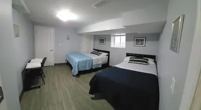 a small room with two beds and a table at Prestige Accommodation in Ajax