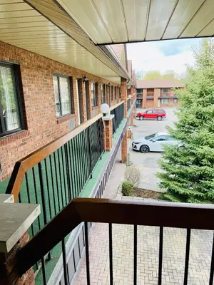 a balcony of a building with a car parked in a parking lot at Toronto Lakeshore Hotel in Mississauga