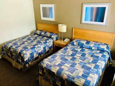 a hotel room with two beds and a lamp at Toronto Lakeshore Hotel in Mississauga