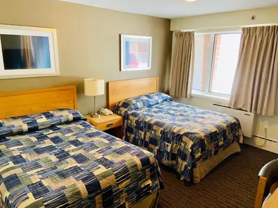 a hotel room with two beds and two windows at Toronto Lakeshore Hotel in Mississauga
