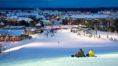 a group of people sitting in the snow in front of a town at Great Location, Pool, Blue Mountain 2 BDRM Dream in Blue Mountains
