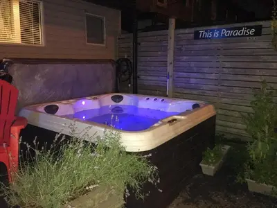 a bath tub sitting outside of a house at Love-nest With Private Hot Tub in Toronto