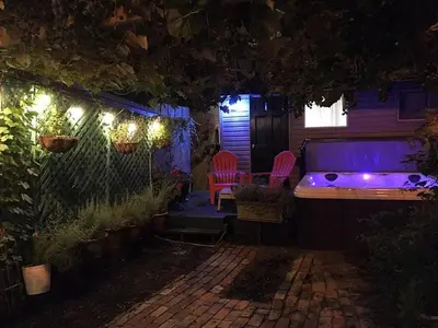 a backyard at night with a hot tub and chairs at Love-nest With Private Hot Tub in Toronto