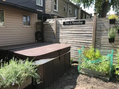 a house with a sign that reads this is paradise at Love-nest With Private Hot Tub in Toronto