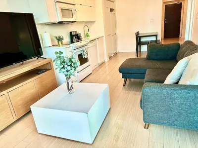 a living room with a vase of flowers on a table at Elegant Downtown Condo Near CN Tower -FREE Parking in Toronto