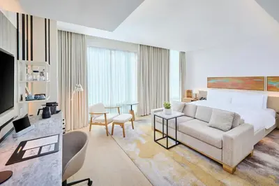 a hotel room with a bed and a living room at The Pearle Hotel & Spa, Autograph Collection in Burlington