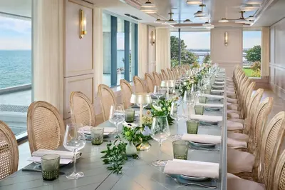 a long table in a room with chairs and wine glasses at The Pearle Hotel & Spa, Autograph Collection in Burlington