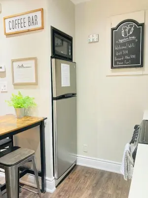 a kitchen with a refrigerator and a wooden table at Blue Mountain Creekside Studio at North Creek Resort in Blue Mountains