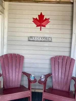 two pink chairs and a sign with a maple leaf at Blue Mountain Creekside Studio at North Creek Resort in Blue Mountains
