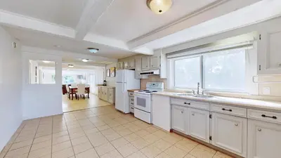 a kitchen with white appliances and a large window at Main Beach River Retreat - Wasaga Beach 1 - Main Strip - 95 Mosley St in Wasaga Beach