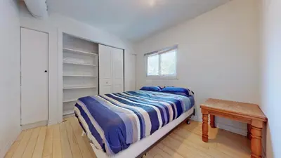 a bedroom with a bed and a table in it at Main Beach River Retreat - Wasaga Beach 1 - Main Strip - 95 Mosley St in Wasaga Beach