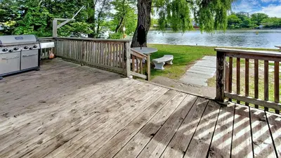 a wooden deck with a stove and a grill at Main Beach River Retreat - Wasaga Beach 1 - Main Strip - 95 Mosley St in Wasaga Beach