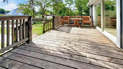 a wooden deck with a table and chairs on a house at Main Beach River Retreat - Wasaga Beach 1 - Main Strip - 95 Mosley St in Wasaga Beach