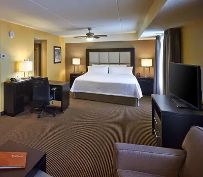 a hotel room with a bed and a flat screen tv at Homewood Suites by Hilton Hamilton in Hamilton