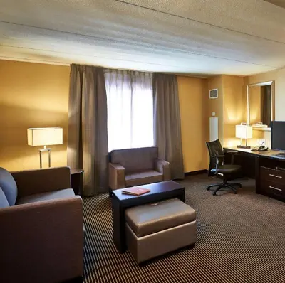 a hotel room with a couch and a desk and chair at Homewood Suites by Hilton Hamilton in Hamilton