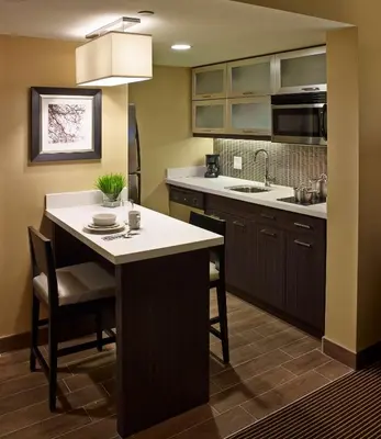 a kitchen with a kitchen island with a sink at Homewood Suites by Hilton Hamilton in Hamilton