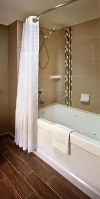 a bathroom with a bath tub with a shower curtain at Homewood Suites by Hilton Hamilton in Hamilton