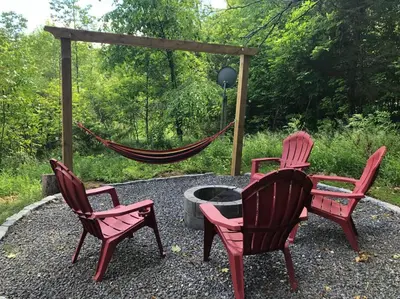 three chairs and a table and a hammock on a patio at The hidden nest in Marmora