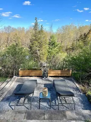 a patio with two chairs and a table and a bench at The hidden nest in Marmora