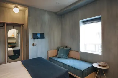 a bedroom with a bed and a bench and a window at Ode in Toronto