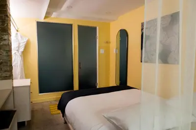 a bedroom with a bed and two large windows at Ode in Toronto