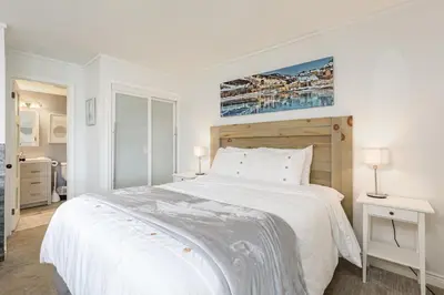 a white bedroom with a large white bed and two lamps at Blue Mountain Studio Oasis in Blue Mountains