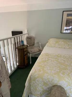 a bedroom with a bed and a chair and a staircase at The Jypsy Inn Chambre Damour Bracebridge in Bracebridge