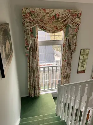 a stairway with a large window with a green carpet at The Jypsy Inn Chambre Damour Bracebridge in Bracebridge