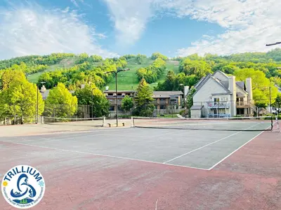 a tennis court in front of a house at Cozy Studio Loft with 2 Baths Next to Slopes in Blue Mountains