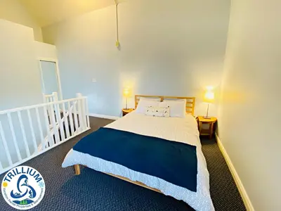 a bedroom with a bed with a blue and white bedspread at Cozy Studio Loft with 2 Baths Next to Slopes in Blue Mountains