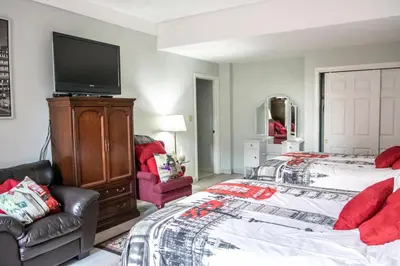 a bedroom with a bed and a flat screen tv at The Jypsy Inn Notting Hill in Bracebridge