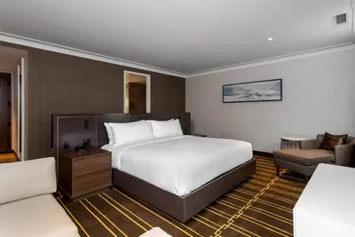 a hotel room with a large bed and a couch at Sutton Place Hotel Toronto in Toronto